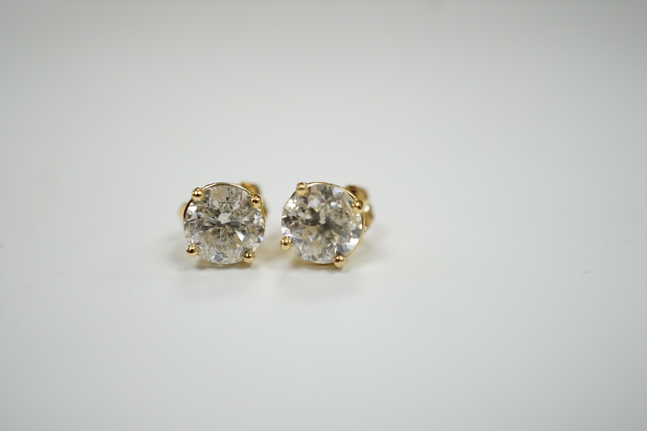 A pair of 750 yellow metal and solitaire diamond set ear studs, with a total carat weight of approximately 1.80ct.